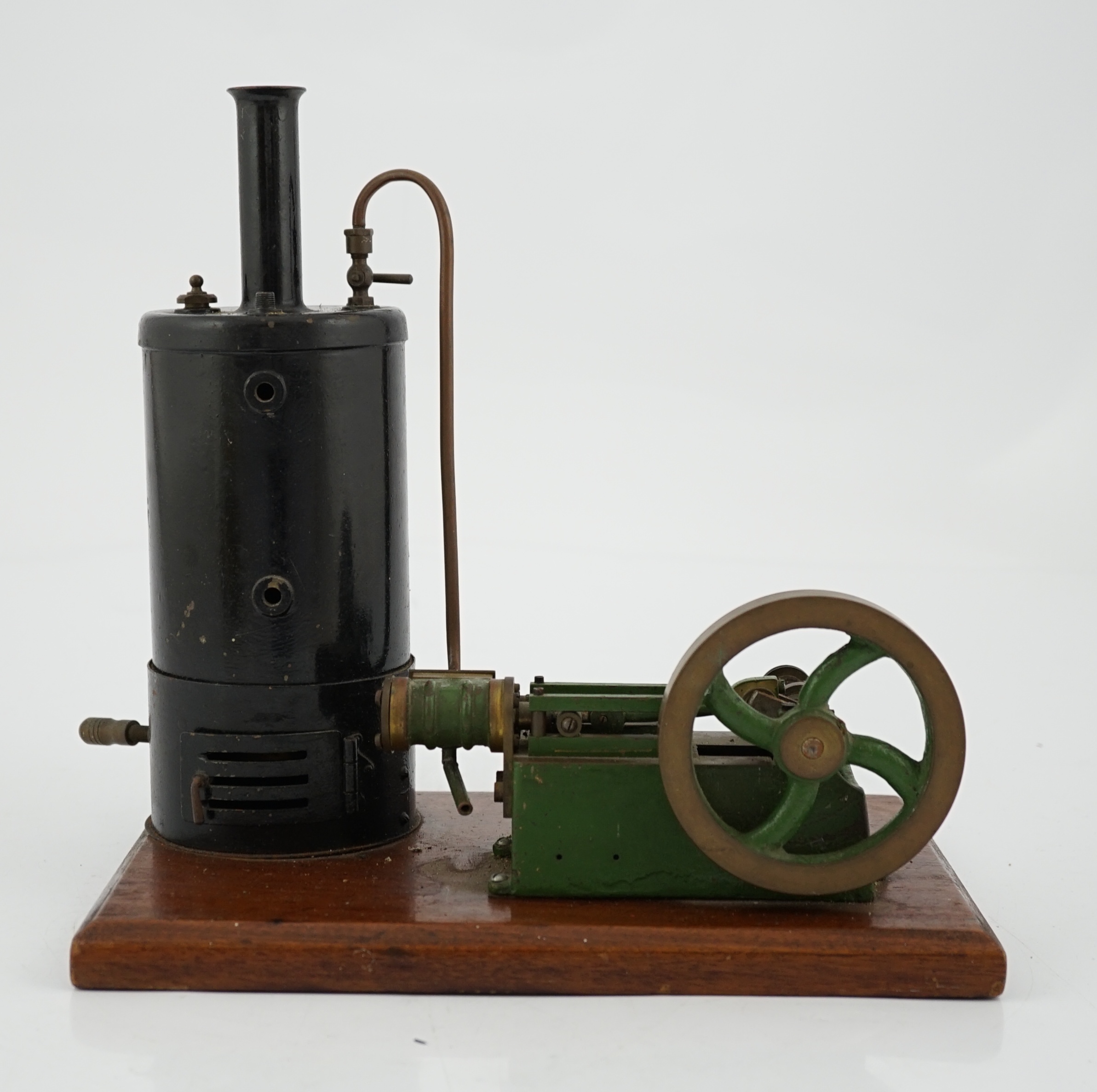 A Stuart Turner style stationary steam plant, with vertical boiler with fittings for a water sight glass and a pressure gauge (both missing), connected to a single cylinder horizontal steam engine with slide valve, mount